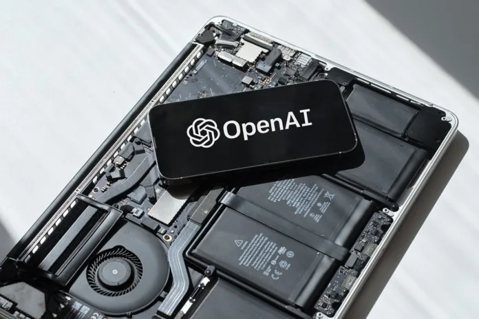 GPT-4o-update-rollback Smartphone displaying OpenAI logo placed on an open laptop motherboard representing GPT-4o update rollback and AI technology.