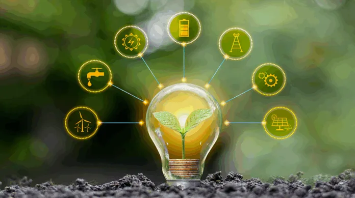 green-technology-innovations Hand holding a glowing green light bulb with leaf icon, symbolizing green technology and sustainable energy, over a map of India.