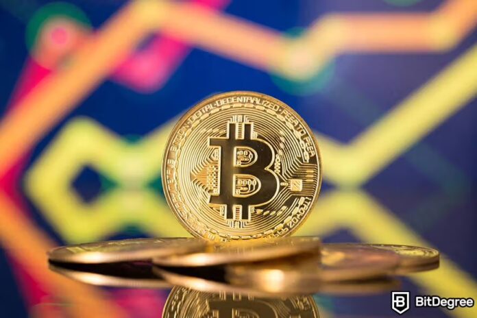 Person holding a Bitcoin coin while viewing a screen with rising cryptocurrency charts, representing ways to earn with Bitcoin during a market peak.