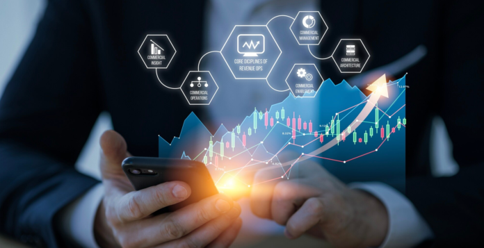 fintech-service-e1703592968417 (1) Businessman using mobile phone with digital analytics and financial technology interface for mobile payments and revenue operations.