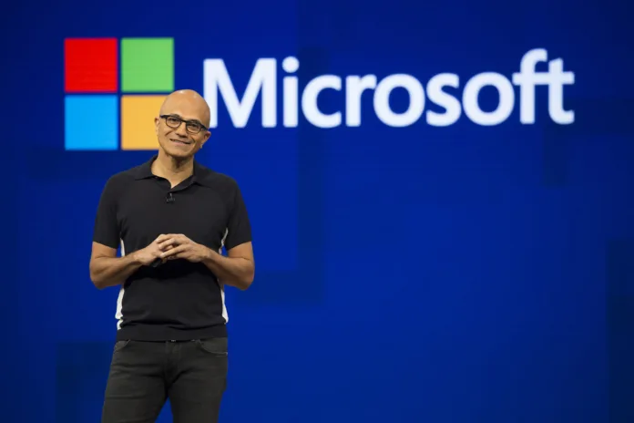 satya-nadella-microsoft-ceo Satya Nadella speaking on stage at a Microsoft event, highlighting the role of computational thinking in software development.